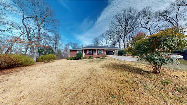 ranch-style house with concrete driveway and a front lawn