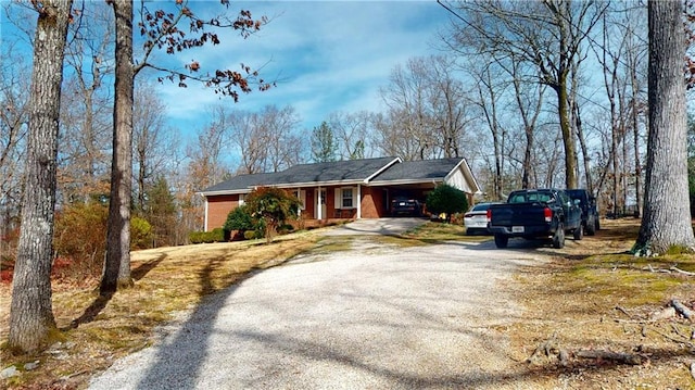 ranch-style house with gravel driveway and brick siding