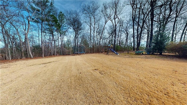 view of yard with a trampoline and playground community