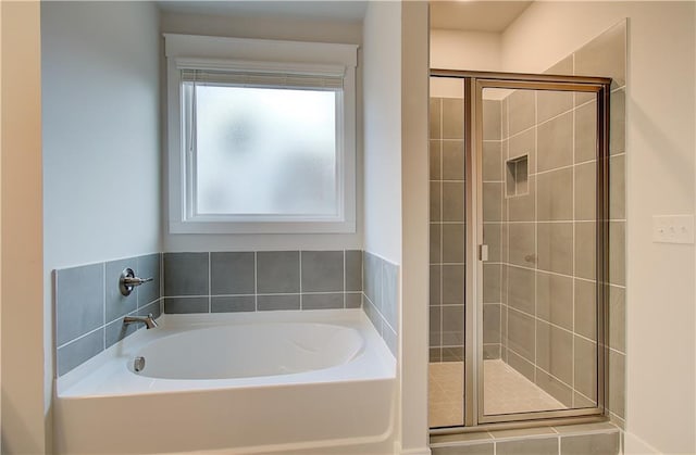 bathroom featuring a shower stall and a garden tub