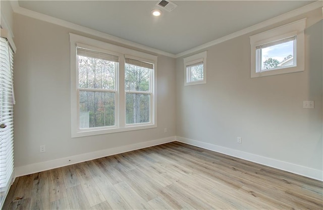 spare room featuring visible vents, light wood-type flooring, and baseboards