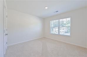 carpeted spare room with baseboards