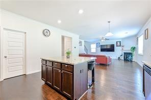 kitchen with light countertops, a glass covered fireplace, a healthy amount of sunlight, and dark brown cabinetry