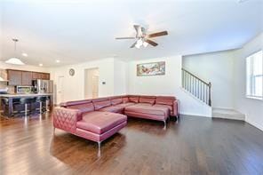 living area with dark wood-type flooring and stairway