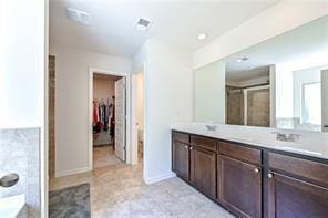 full bath featuring visible vents, a spacious closet, vanity, and baseboards