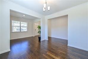 spare room featuring baseboards, ornamental molding, and wood finished floors