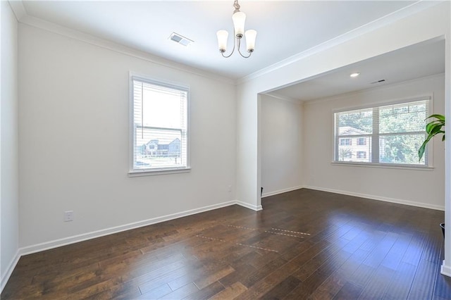 unfurnished room with dark wood-style floors, baseboards, crown molding, and an inviting chandelier