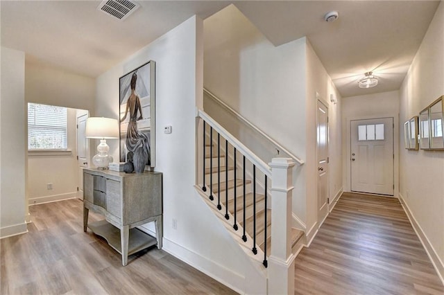 interior space featuring visible vents, stairway, baseboards, and wood finished floors