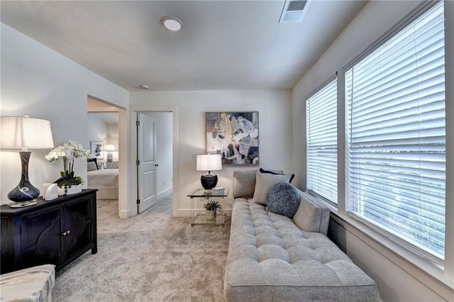 living room with baseboards, visible vents, and light colored carpet