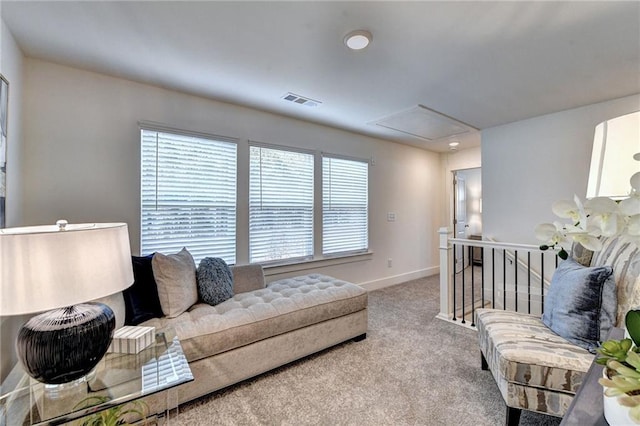 living area with light carpet, baseboards, and visible vents