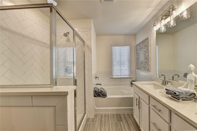 full bath featuring a stall shower, tile walls, a bath, and vanity