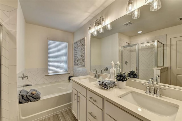 bathroom featuring visible vents, a sink, a garden tub, and double vanity