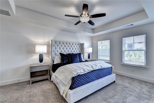 bedroom featuring carpet, a raised ceiling, and visible vents