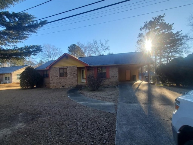 single story home with a carport, concrete driveway, and brick siding