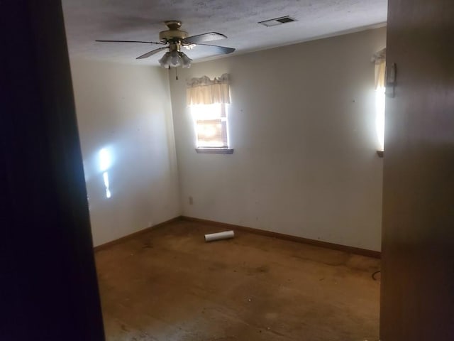 unfurnished room featuring visible vents, ceiling fan, and baseboards