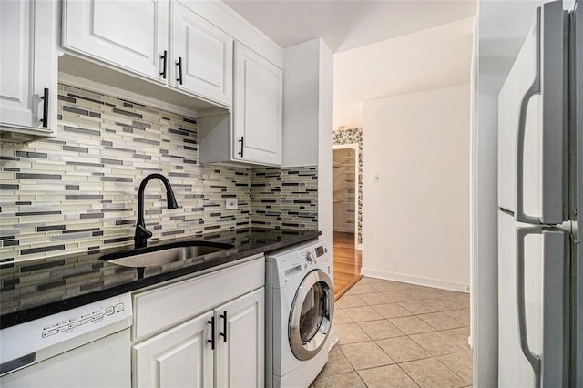 kitchen featuring a sink, white appliances, white cabinets, light tile patterned floors, and washer / dryer