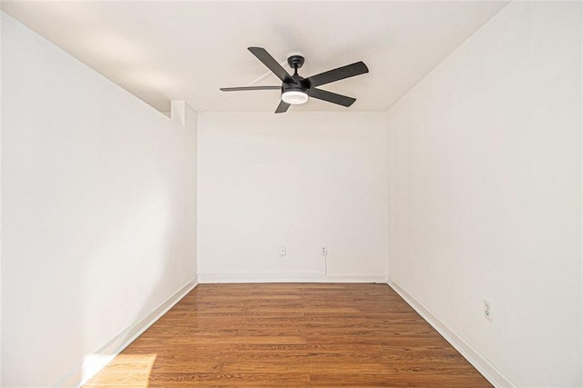 empty room featuring baseboards, wood finished floors, and a ceiling fan