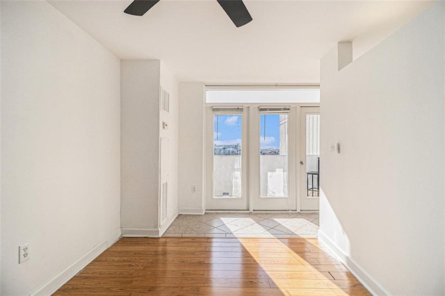 foyer entrance with visible vents, baseboards, a ceiling fan, and hardwood / wood-style flooring