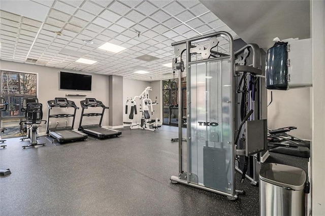 exercise room featuring baseboards and a paneled ceiling