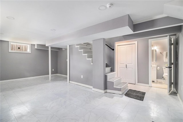 below grade area with baseboards, marble finish floor, and stairs
