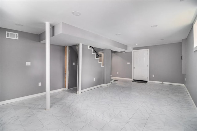 finished basement with stairs, baseboards, and visible vents