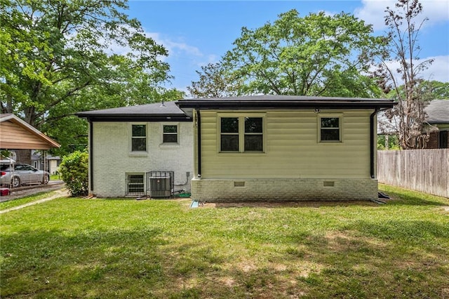 view of front facade featuring crawl space, central AC, fence, and a front lawn
