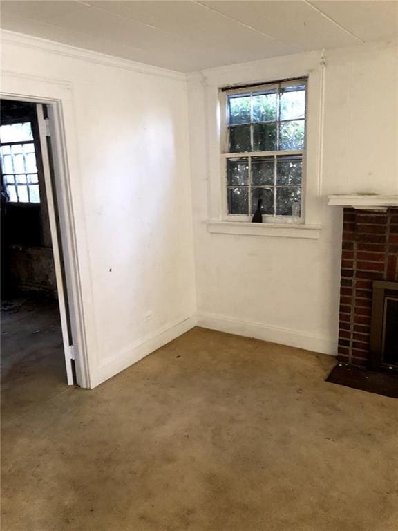 unfurnished living room with a brick fireplace, baseboards, and concrete flooring