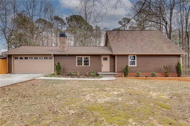 view of front of house featuring a garage, concrete driveway, a chimney, and roof with shingles