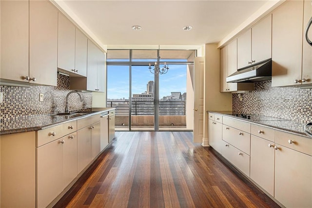 kitchen with decorative light fixtures, decorative backsplash, sink, dark hardwood / wood-style flooring, and black electric cooktop