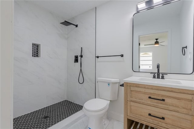 bathroom with vanity, toilet, and a tile shower