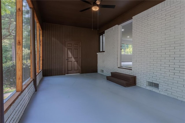 unfurnished sunroom with ceiling fan