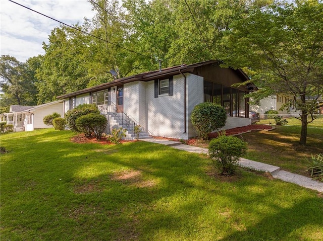 view of front of property featuring a front lawn and a sunroom