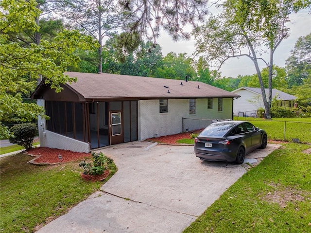 view of front of property featuring a sunroom and a front lawn