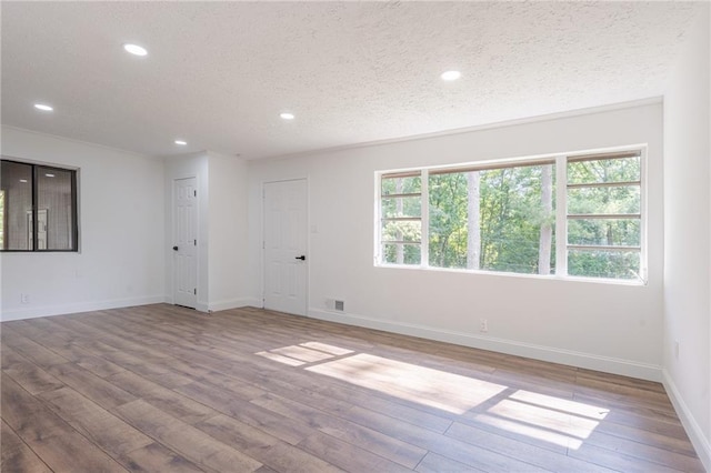 unfurnished room featuring a textured ceiling and light wood-type flooring