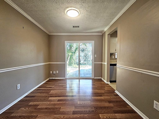 spare room featuring ornamental molding, dark hardwood / wood-style floors, and a textured ceiling