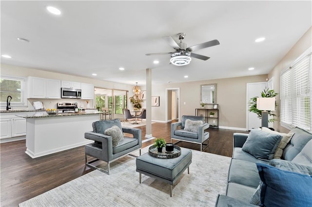 living room featuring ceiling fan, sink, and dark hardwood / wood-style flooring