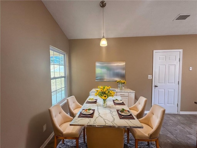 dining space featuring vaulted ceiling