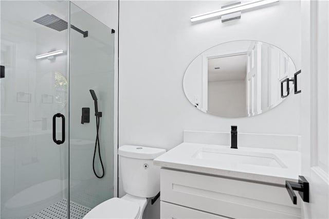 bathroom featuring vanity, an enclosed shower, and toilet