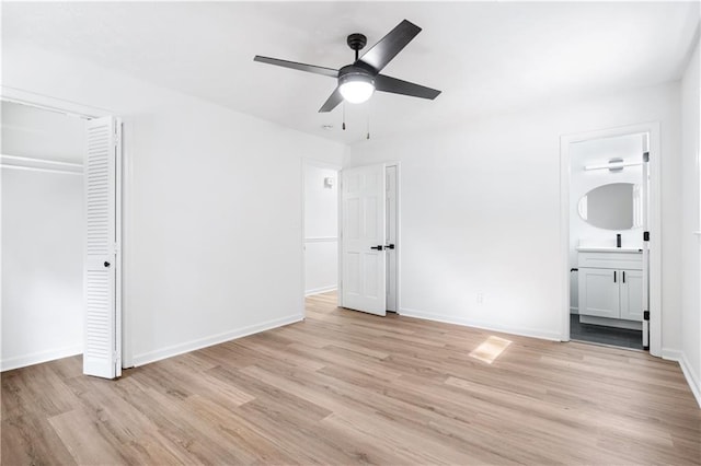 unfurnished bedroom with ceiling fan, ensuite bath, and light wood-type flooring