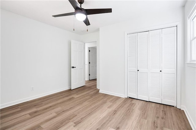 unfurnished bedroom featuring light hardwood / wood-style floors, ceiling fan, and a closet