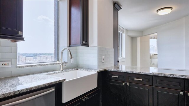 kitchen with tasteful backsplash, plenty of natural light, and light stone countertops