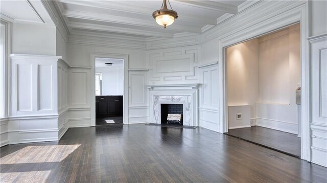 unfurnished living room with a high end fireplace, beamed ceiling, ornamental molding, and hardwood / wood-style floors