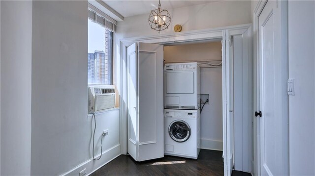 clothes washing area with an inviting chandelier, cooling unit, dark hardwood / wood-style floors, and stacked washer and dryer