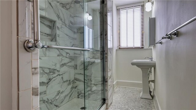 bathroom with a shower with shower door and a wealth of natural light