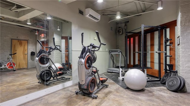 exercise area featuring an AC wall unit and concrete flooring