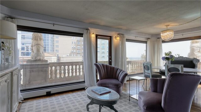 living room featuring a chandelier, hardwood / wood-style floors, and a baseboard radiator