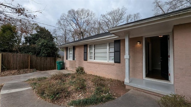 view of home's exterior with brick siding and fence