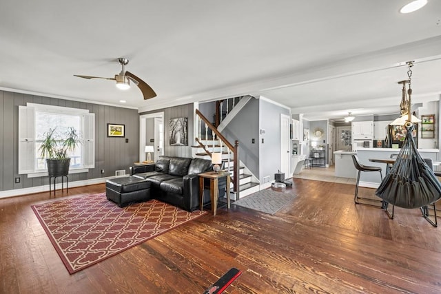 living room featuring crown molding, wood-type flooring, and ceiling fan