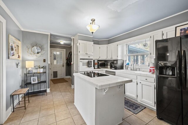 kitchen featuring tile countertops, sink, white cabinets, light tile patterned floors, and black appliances