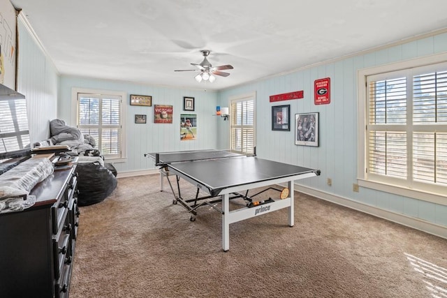 rec room with crown molding, ceiling fan, and carpet